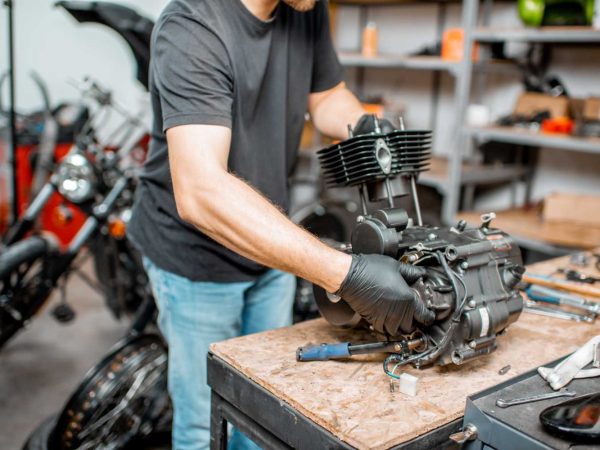 man-repairing-motorcycle-engine-resize.jpg